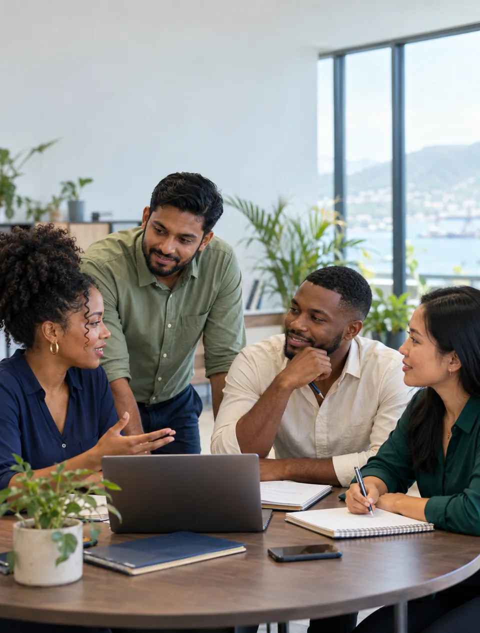 Young professionals collaborating around a laptop in a bright office